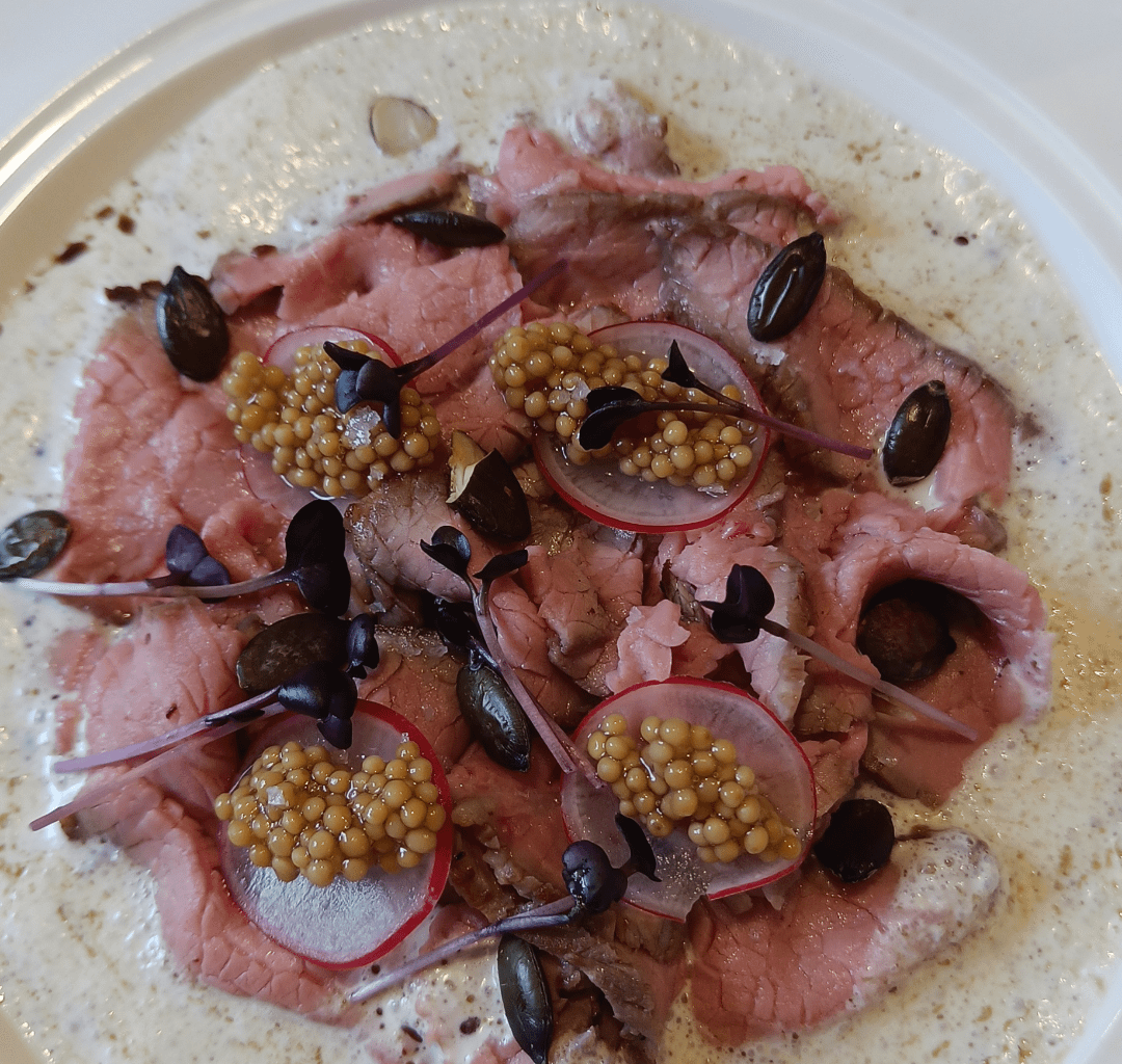 Carpaccio mit Radieschen und Senfkaviar auf Parmesan und Kürbiskernölschaum