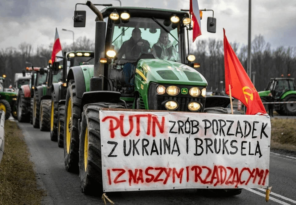 Polish farmers with a Soviet flag on the Ukrainian border. The banner reads: "Putin, bring order to Ukraine, Brussels and our government".