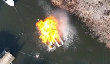 Two Russian soldiers on a boat in civilian clothing are hit with an accurate drone dropped grenade strike injuring them and igniting the fuel, they manage to swim to shore but can be seen bleeding heavily.