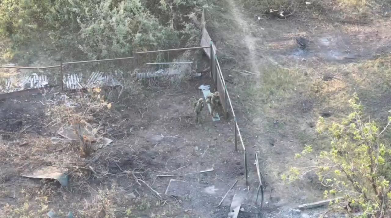 2 Russian soldiers attempt to fend off an FPV drone.