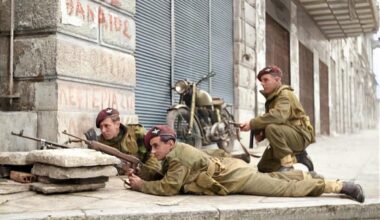 6 December 1944.
Paratroopers from the 5th (Scots) Parachute Battalion, 2nd Parachute Brigade, take cover on a street corner in Athens during a street fight against members of ELAS.
L/Cpl D Fairbanks, Pte J E Gregory, and Cpl W Lannery (kneeling).