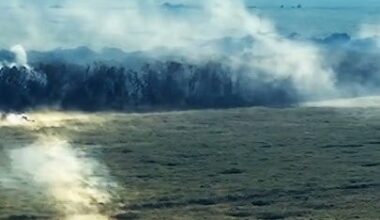 An ostensibly Ukrainian tank fires on a treeline with visible shockwaves from the shells