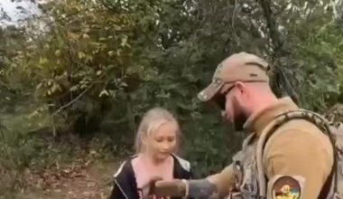 UA soldier gives yellow blue bracelet to Russian girl