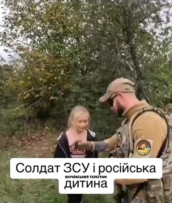 UA soldier gives yellow blue bracelet to Russian girl