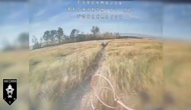 A Russian soldier carrying a gas canister back to his position through an open field is getting chased by a Ukrainian FPV quad.