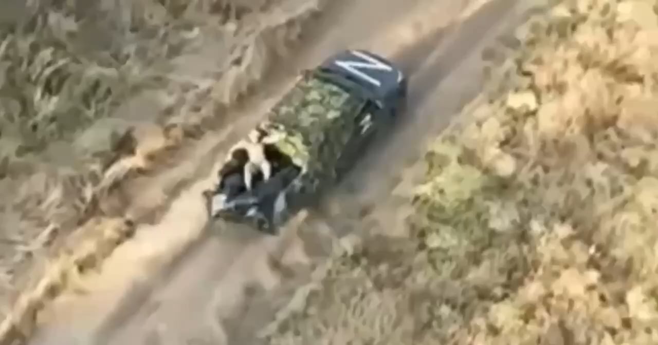 A Russian is dumping comrade's dead bodies from the truck to help it outrun the chasing drone.