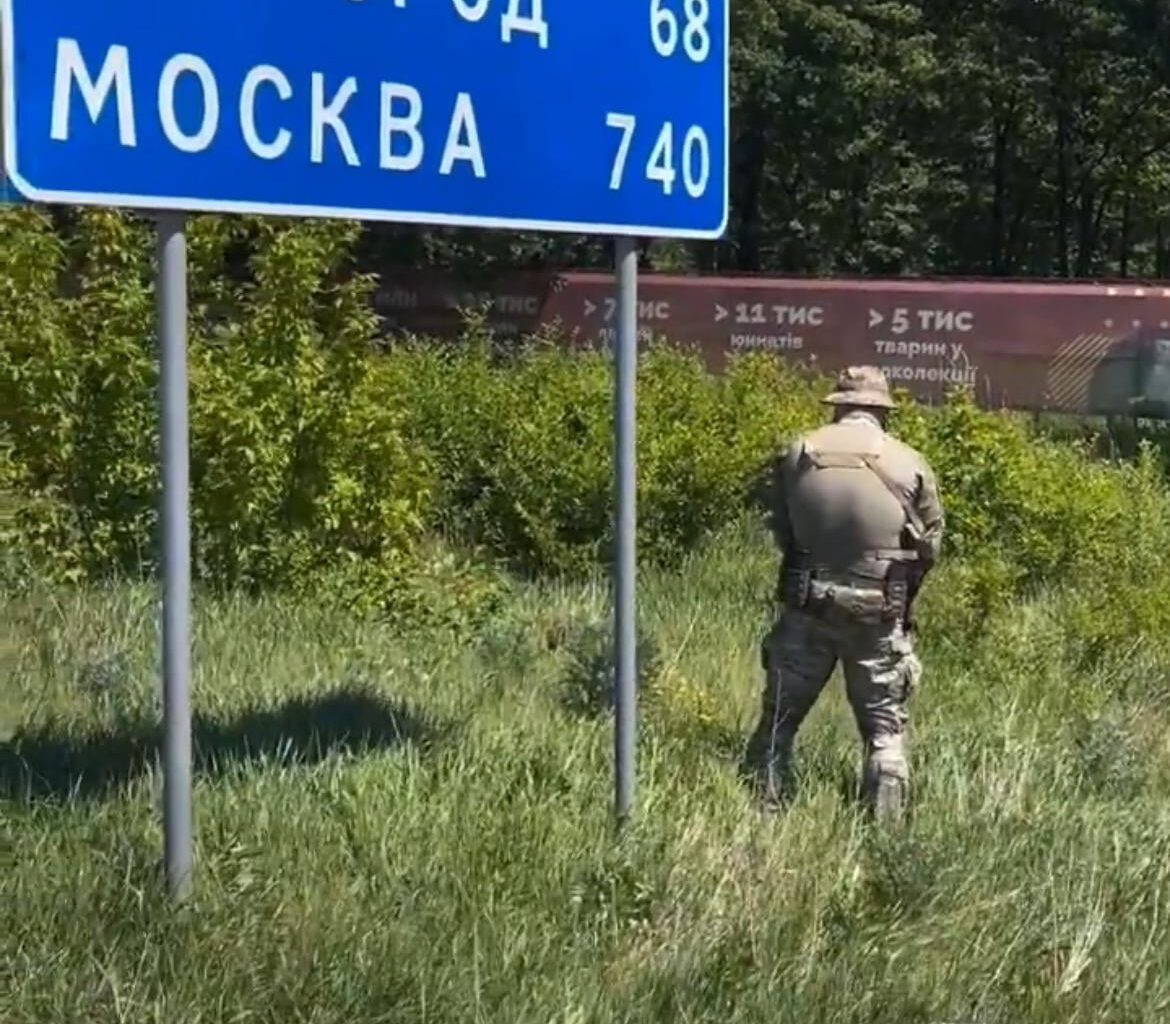 Soldier from the Ukrainian Army, 'relieving himself' at a road sign with has Moscow (740), afterwards he wipes his hands on the sign.