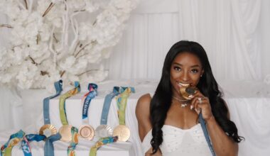 Simone Biles posing with her 11 Olympic medals