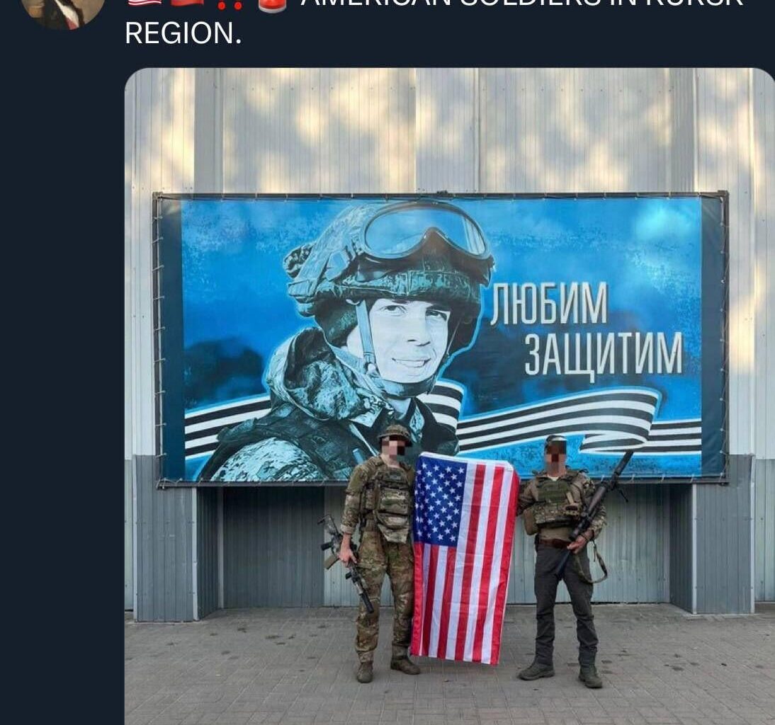 Two UA fighters posing with an American flag in front of a recruiting and or motivational RF AF poster.