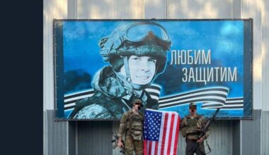 Two UA fighters posing with an American flag in front of a recruiting and or motivational RF AF poster.