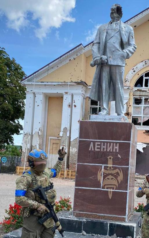 A Ukrainian soldier poses for a photo in front of a Russian Statue in the Kursk Region - August 2024