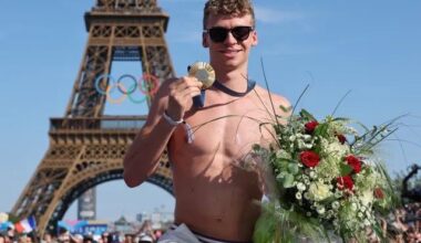 Léon Marchand poses with one of his four gold medals at the Champions Park at Trocadero.