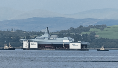 Royal Navy's new Type 26 frigate floating down the River Clyde on a massive barge