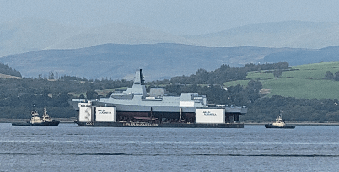 Royal Navy's new Type 26 frigate floating down the River Clyde on a massive barge