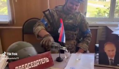 Ukrainian Army soldier pours himself a shot of vodka, at a captured Russian administration building/office – in the Kursk Oblast.