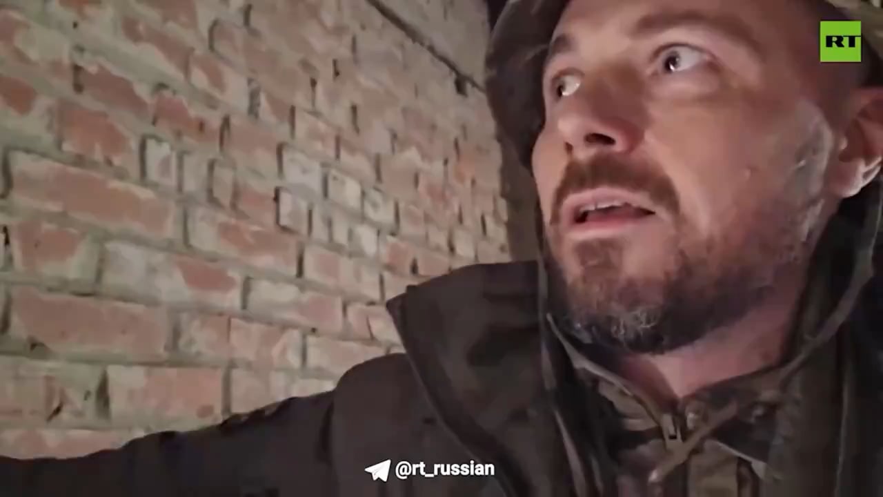 Russian RT reporter/combatant films himself hiding in a factory in Donbas when an FPV drone enters the building. The drone explodes inside the factory but fails to cause casualties. September 2024