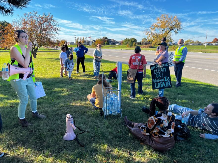  Beth Vild standing speaking to protesters sitting around her. 