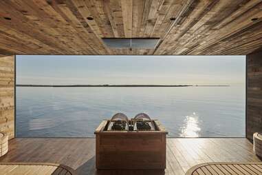 a sauna with a large window pane looking out to the ocean