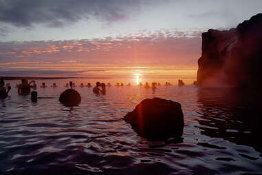 people in a lagoon as the sun sets