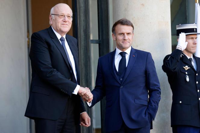 France's President Emmanuel Macron shakes hands with Lebanon's Prime Minister Najib Mikati as he welcomes him prior to their meeting at the Elysée Palace in Paris on October 23, 2024. 