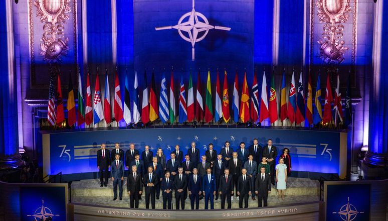 The Heads of State and Government of the 32 NATO Allies and the NATO Secretary General stand together in the Mellon Auditorium in Washington, D.C. – the same room where the 12 founding NATO Allies signed the North Atlantic Treaty 75 years before, on 4 April 1949.