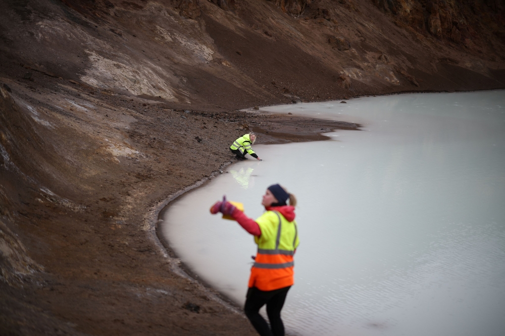 Michelle Parks, a volcanologist at the Icelandic Meteorological Office (IMO), and Asta Rut Hjartardottir, a geophysicist at IMO, measure the temperature and acidity of Askja volcano's Viti crater lake, in Vatnajokull National Park, Iceland, August 9, 2024. — Reuters pic  