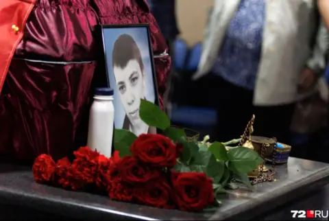 72.ru Iryna Sharova A close-up of a photo of Lipavsky and some roses next to his coffin