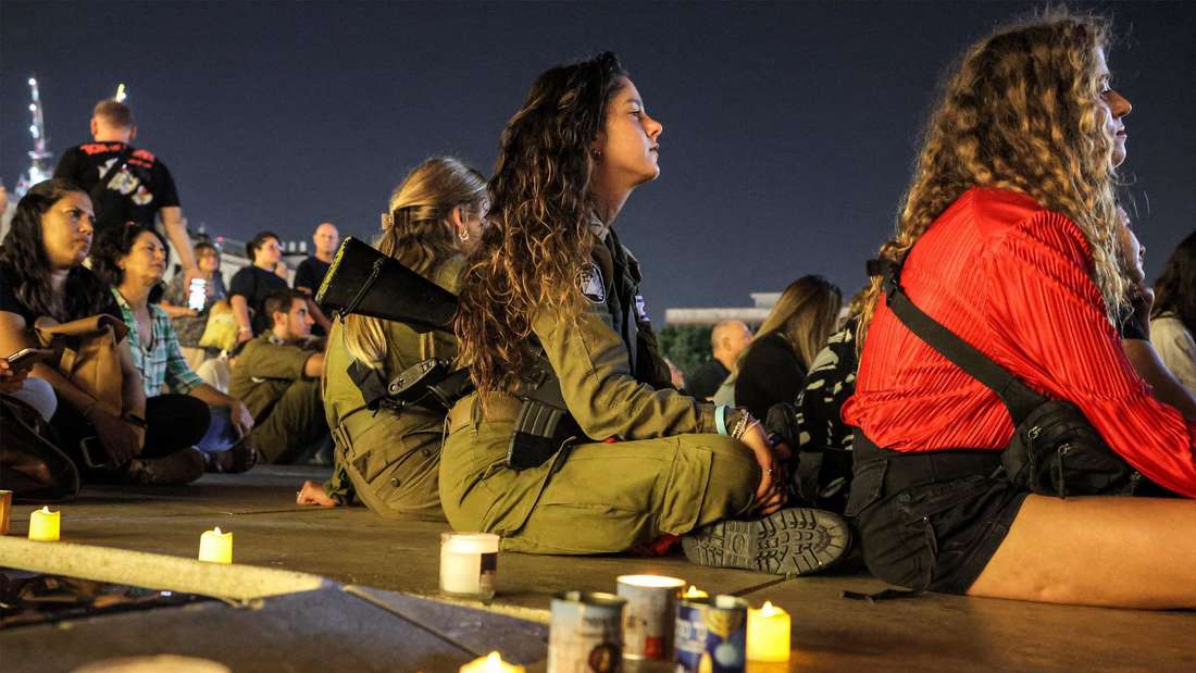 Seit Oktober: Israelische Reservistinnen und Soldaten, Frauen und Männer nehmen am 7. November, einen Monat nach den Angriffen der Terrororganisation Hamas auf den Süden des Landes, an einer von Kerzen beschienenen Mahnwache auf dem Kikar Dizengoff in Tel Aviv teil. Die Massaker, bei denen um die 1200 Menschen getötet wurden, versetzen das Land in einen Schockzustand, von dem es sich nur langsam löst. Während man sich weitestgehend einig ist, dass die Hamas nicht mehr länger hingenommen werden kann, melden sich auch immer mehr Stimmen, die der Regierung Netanjahu Versagen aus eigenem Interesse vorwerfen. rut/Bild: JACK GUEZ/AFP