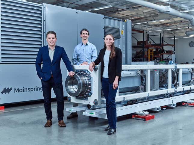 three people stand together around a linear generator