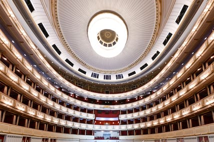 Blick in den Saal der Wiener Staatsoper mit beleuchteten Rängen und Kuppeldach