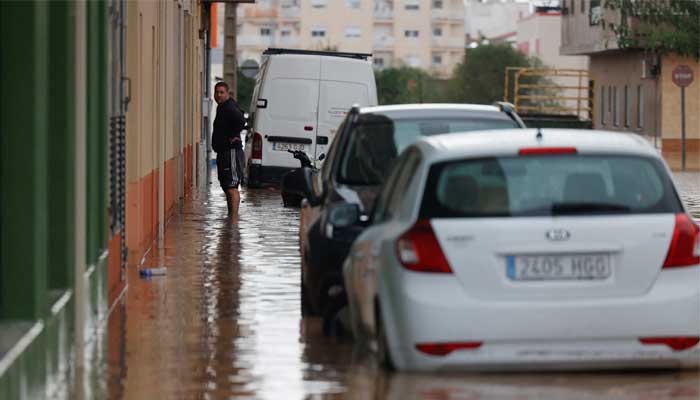 A person stands in a flooded street after the Spanish meteorological agency put the Valencia region in the highest red alert for extreme rainfalls, in Catadau, Valencia, Spain on October 29, 2024. — Reuters