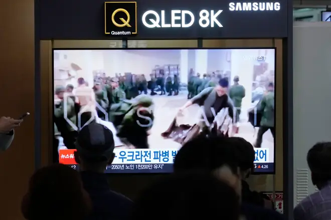 A TV screen shows an image of soldiers believed to be from North Korea stand in line to receive supplies from Russia during a news program at Seoul Railway Station in Seoul