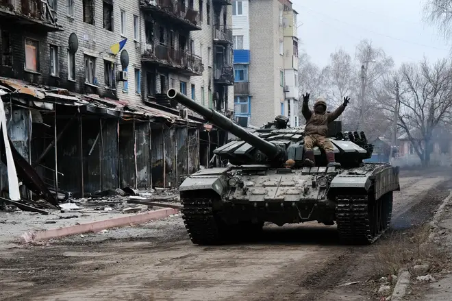 A Ukrainian tank drives down a street in the heavily damaged town of Siversk which is situated near the front lines with Russia