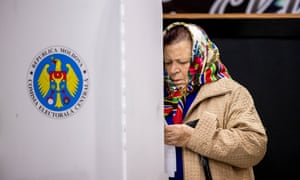 A woman looks at her ballot paper in a voting booth in Moldova. Photograph: EPA/Dumitru Doru