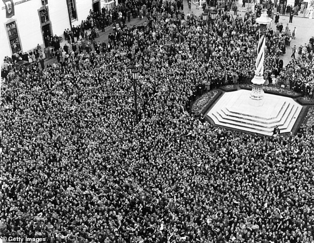 Thousands of people gather in the streets of Lisbon to greet the Queen and Prince Philiip