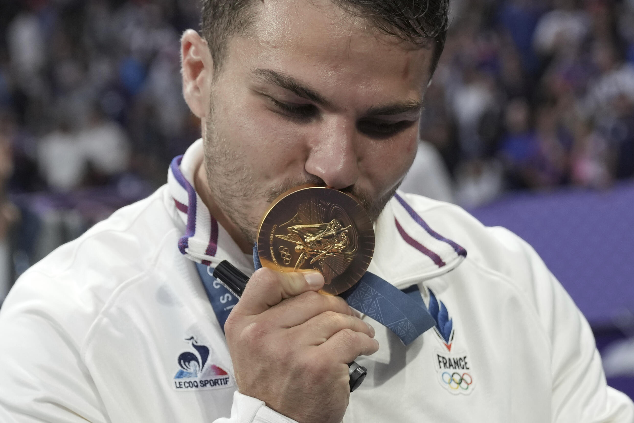 Antoine Dupont of France kisses his gold medal as he celebrates after France won the men's Rugby Sevens gold medal at the 2024 Summer Olympics, in the Stade de France, in Saint-Denis, France, Saturday, 27 July 2024.