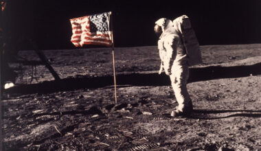 FILE - Astronaut Edwin "Buzz" Aldrin poses for a photograph beside the U.S. flag deployed on the mo...