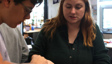 Science teacher Caroline Gambill helps students set up relaxing chambers for the dead bugs.