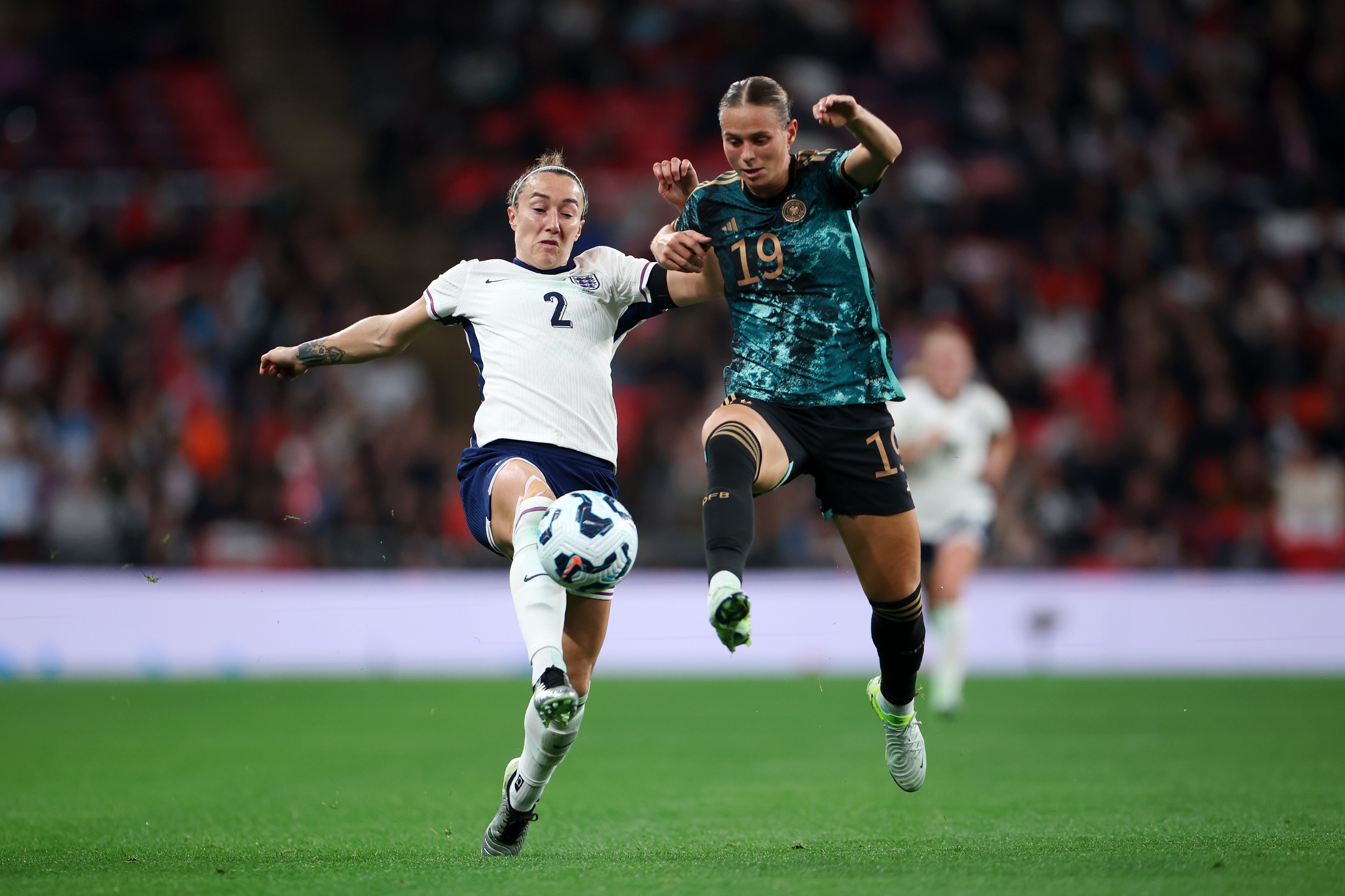 Lucy Bronze of England, left, and Klara Buhl compete for the ball