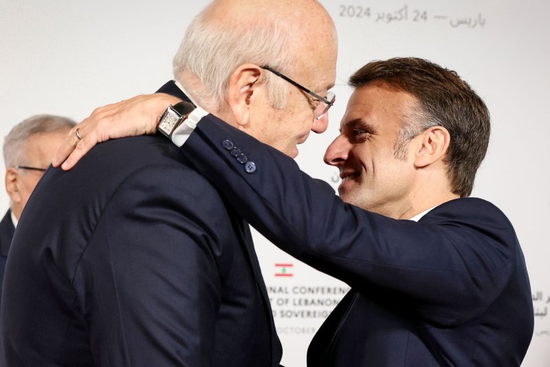 Lebanese Prime Minister Najib Mikati (L) is welcomed by French President Emmanuel Macron on Thursday at an international summit in Paris organized to raise funds to assist his country. Photo by Alain Jocard/EPA-EFE