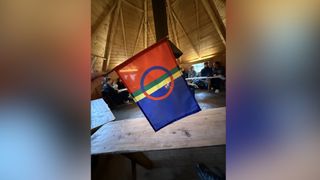 the sami flag is red, green, yellow and blue striped with a circle just off center.