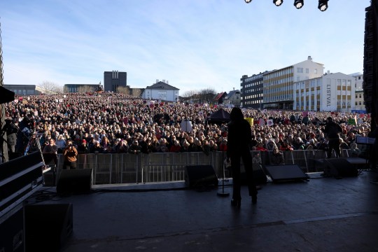 People across Iceland gather during the women's strike in Reykjavik, they stand near a stage