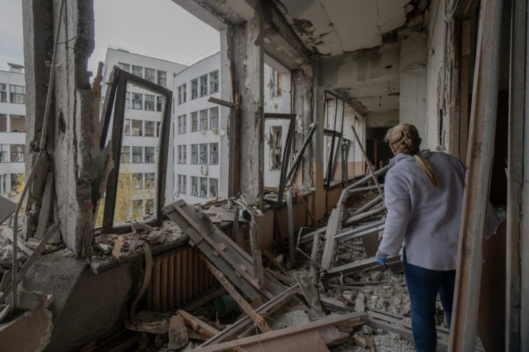 A woman inspects damage to the Derzhprom building, a historic Soviet skyscraper, following a missile attack in Kharkiv on October 29, 2024. (Photo by Ivan SAMOILOV / AFP) (Photo by IVAN SAMOILOV/AFP via Getty Images)