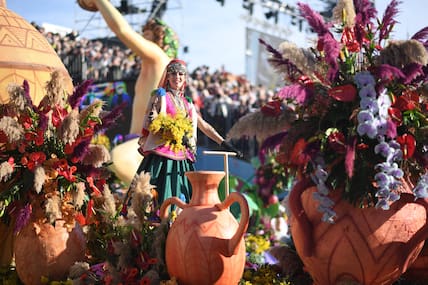 Umzug während des Karnevals von Nizza mit einer verkleideten Frau und vielen Blumen in Tonvasen