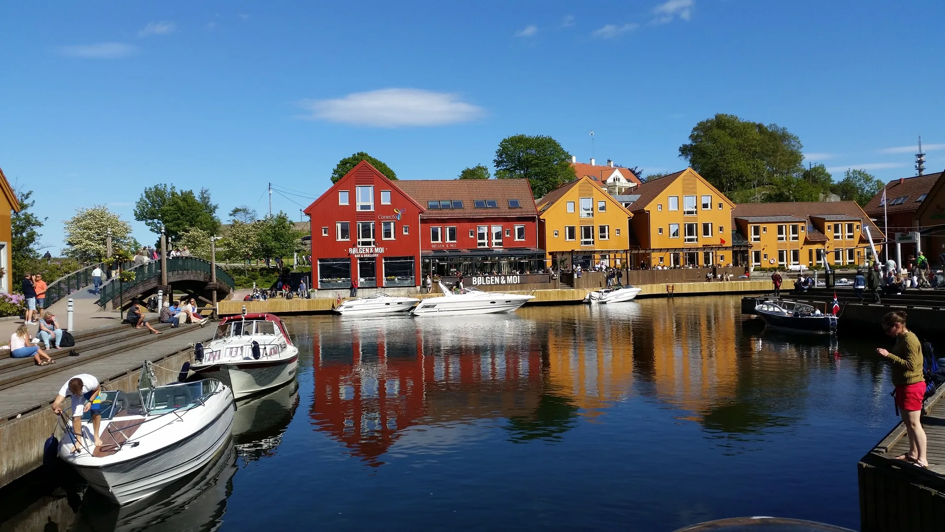 Kristiansand in Norway. Colourful buildings in front of a marina with small boats docked.