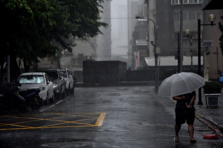 People in Taiwan's capital, Taipei, battle strong winds and rain ahead of the arrival of Typhoon Kong-rey on Friday [Alastair Mccready/Al Jazeera]