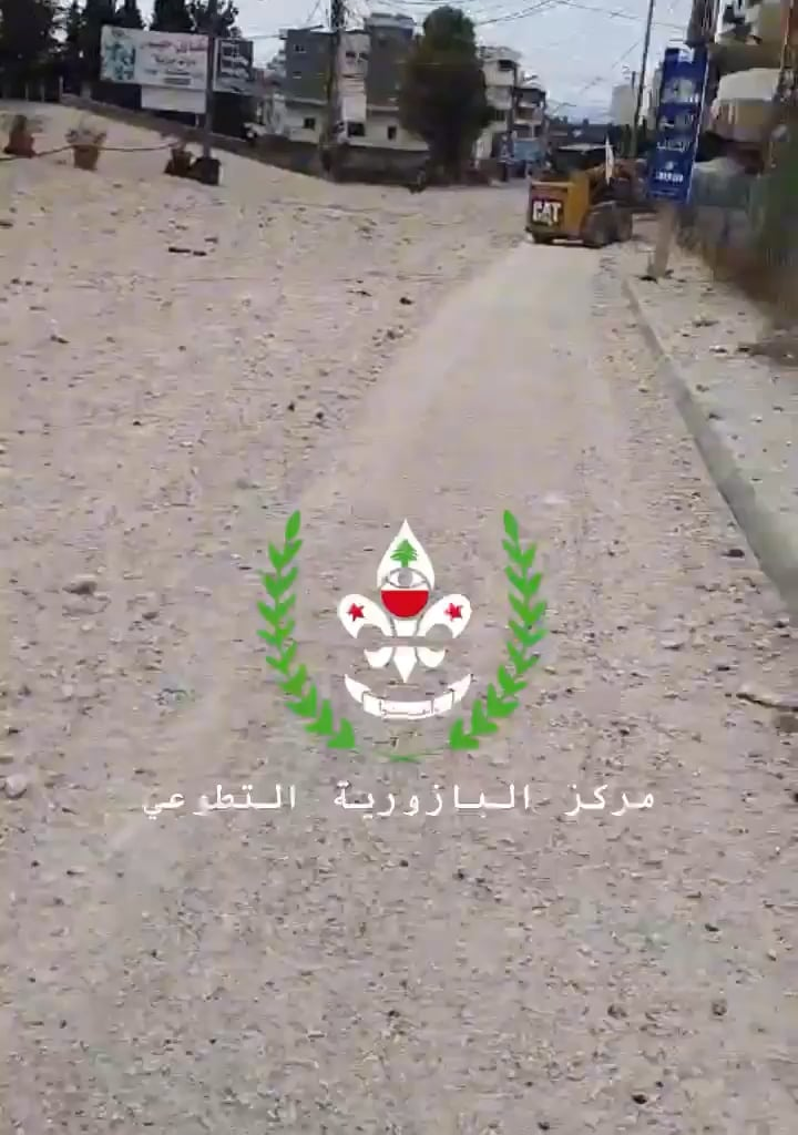 Lebanese civilians filming the debris, while an incoming rocket falls behind him