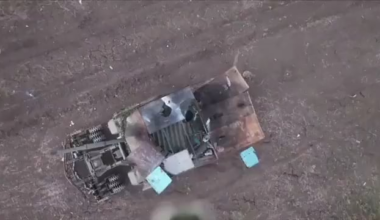 A Ukrainian drone operator drops an M67 grenade through the open hatch of a Russian T-72B3 "Turtle" MBT equipped with a mine roller.