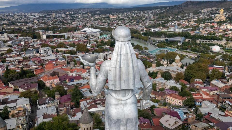 The Mother of Georgia in Tbilisi sculpture welcomes visitors with a bowl of wine, but holds a sword to symbolise Georgia's independence