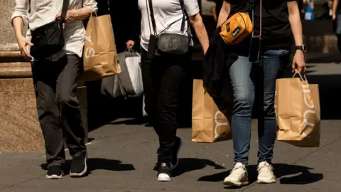 Getty Images Shoppers carry Macy's bags outside the company's flagship store in New York, US, on Friday, 13 September 2024. 